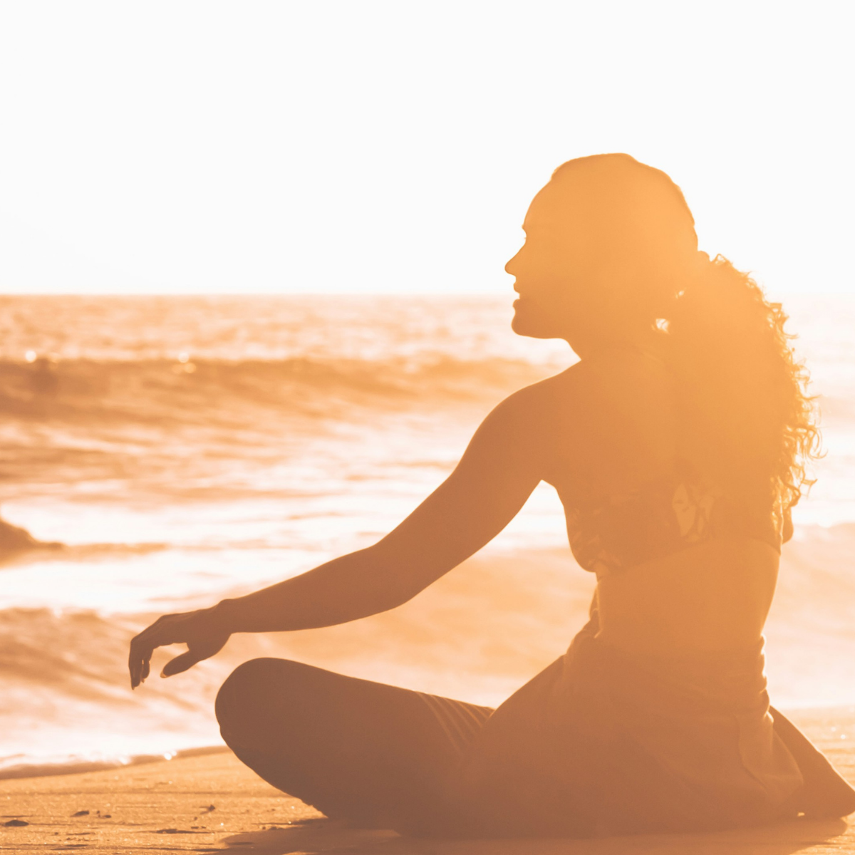 Woman reflecting by the water, representing spiritual goals for women seeking grounding and peace